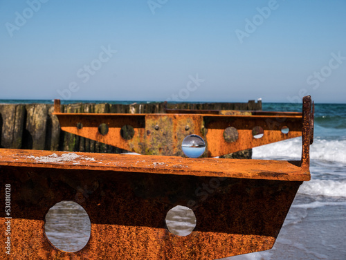 Meeresblick mit verrosteten Buhnen und Glaskugel Küstenstadt Kühlungsborn an der Ostseeküste von Mecklenburg-Vorpommern photo