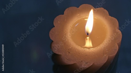 a burning candle on a blue background on the side