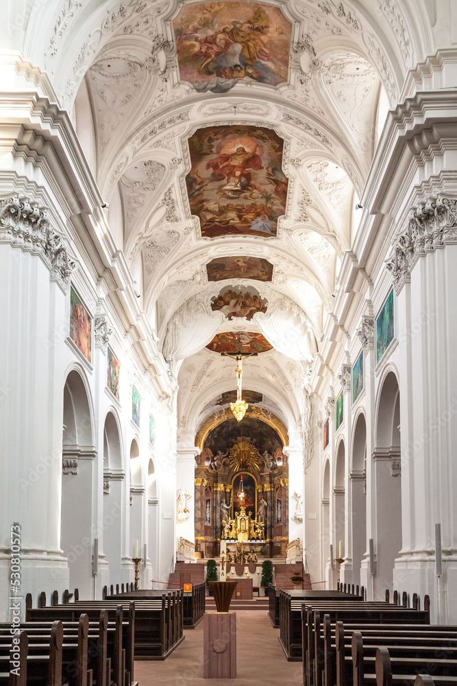Lovely view of the nave of the famous Neumünster Collegiate church in Würzburg, Germany. The church interiors are adorned with breathtaking paintings that cover its ceilings as well as the walls. 