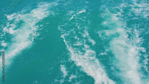 Wake of vessel. Wide awake trail from boat. Back view. Ocean water. Deep blue. Trace from large ship.Slow motion