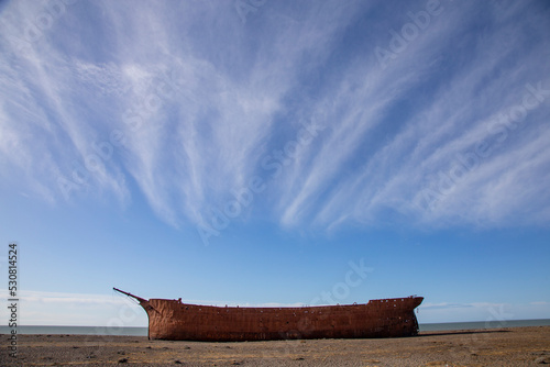 Lonely and old ship called Marjory Glenn abandoned and rusty on the beach on a sunny day photo