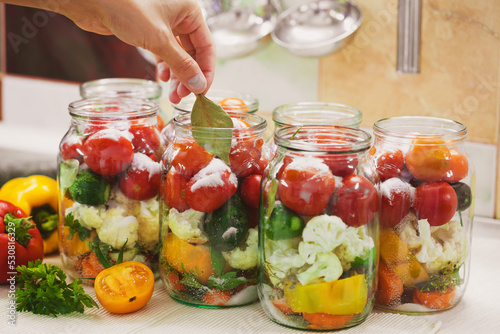 The process of preserving cucumbers and tomatoes for the winter.