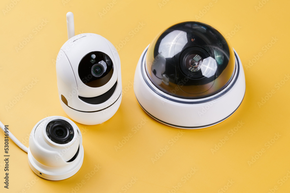 Surveillance cameras, set of different videcam, cctv cameras isolated on yellow background close up. home security system concept Surveillance cameras, set of different videcam, cctv cameras isolated on yellow background close up. home security system concept