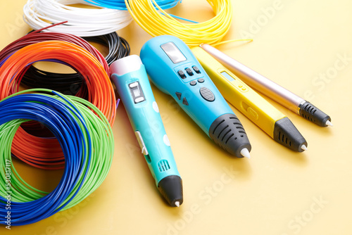 3d pen for creating volume plastic figures isolated on yellow background © amixstudio