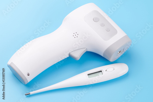 Set of temperature measurement electronic devices. Isometric Digital Infrared Non-Contact Thermometer Gun isolated on blue background. medical diagnostic and healthcare concept