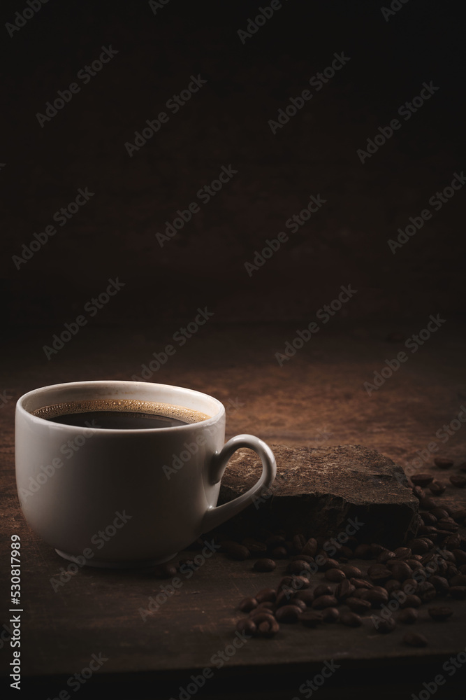 Cup of freshly brewed roasted coffee beans on brown background Cup of freshly brewed roasted coffee beans on brown background