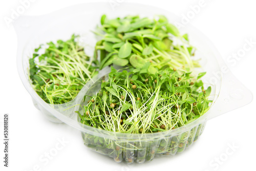 Microgreens mix in disposable plastic packaging isolated on white background.