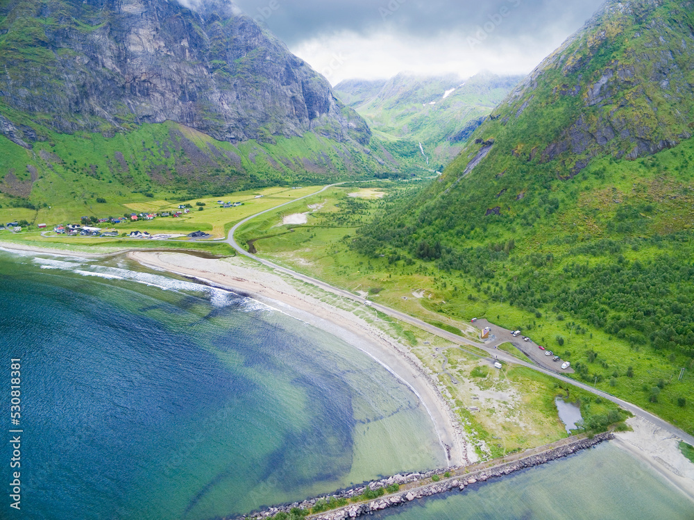 Aerial view of sundy Ersfjord beach surrounded by craggy peaks hidden in clouds, Senja, Norway