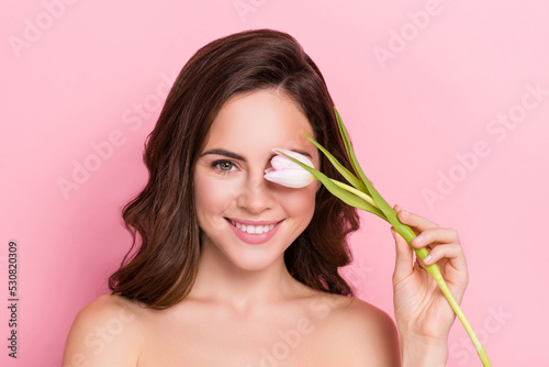 Photo of shy charming young nude lady wear nothing tulips blossom close eye isolated pink color background