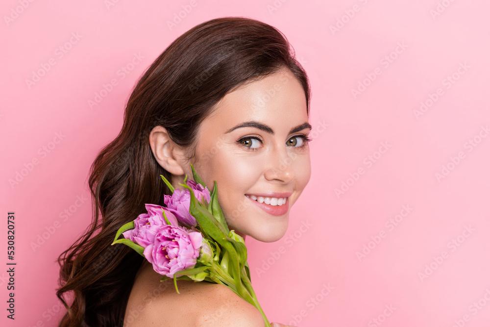Profile side view portrait of attractive cheery girl holding flower sensitive isolated over pink pastel color background