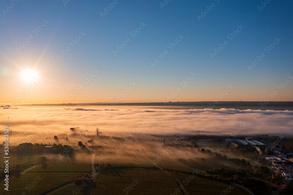 Obraz premium Aerial view of a beautiful sunrise in autumn over the Rhine in the morning mist near Eltville/Germany