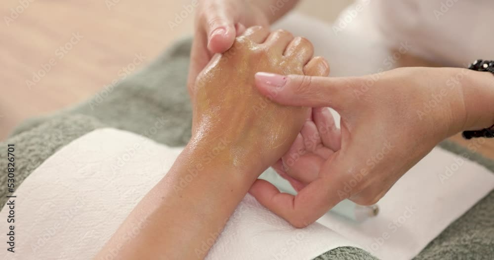 Close up of an unrecognizable young woman enjoying hand massage and manicure in a beauty spa salon.