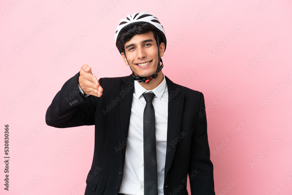 Argentinian businessman with bike helmen isoleted on pink background Argentinian businessman with bike helmen isoleted on pink background