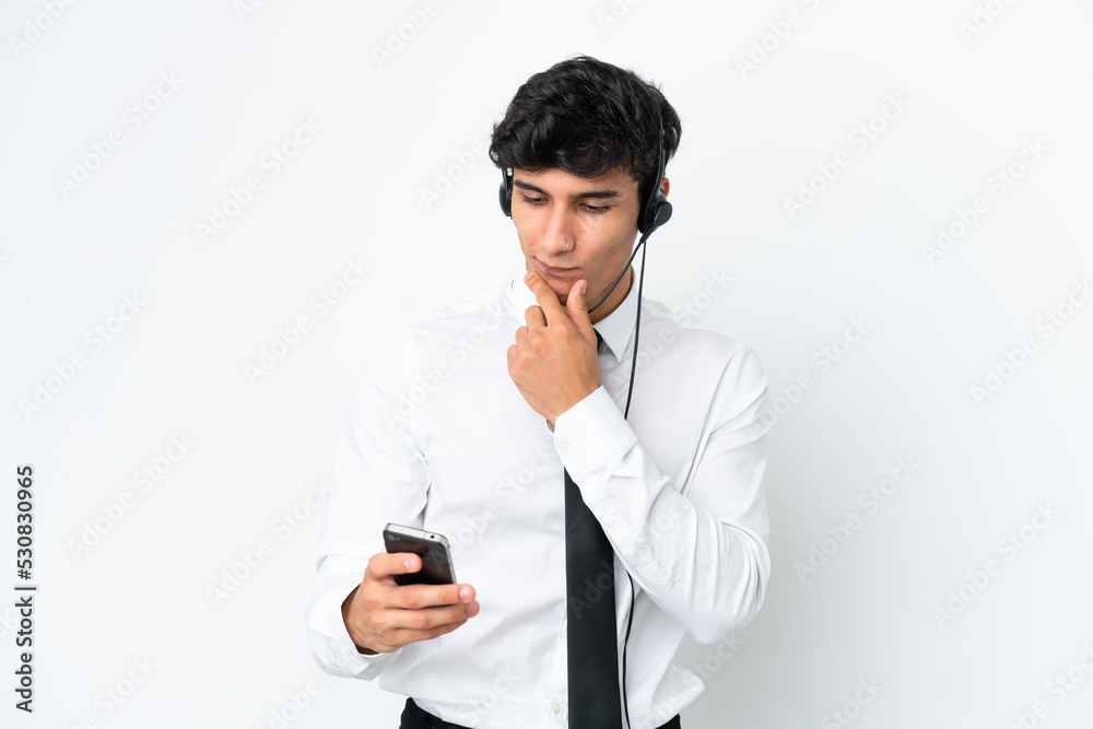 Telemarketer man working with a headset isolated on white background thinking and sending a message Telemarketer man working with a headset isolated on white background thinking and sending a message