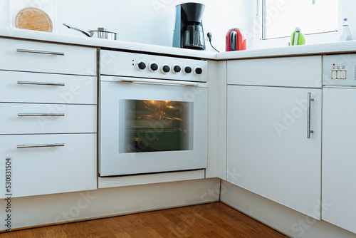 Mini kitchen with white facades, electric oven for smart studio apartment