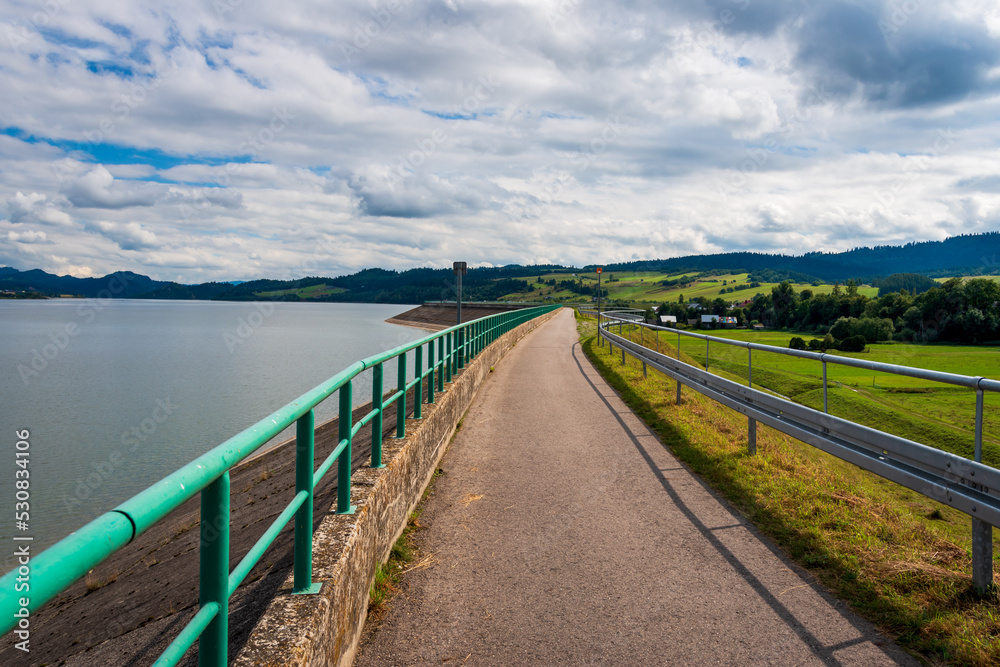 Velo Czorsztyn - beautiful-located bicycle route leading along the coast of the Czorsztynskie Lake. Asphalt road with breathtaking views at water and Pieniny Mountains.