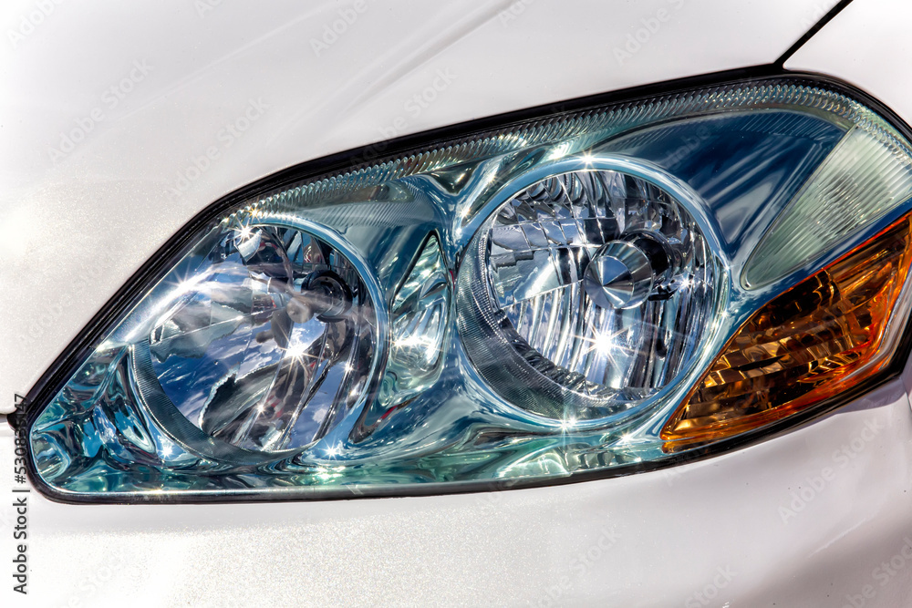 front headlight of a white car close-up