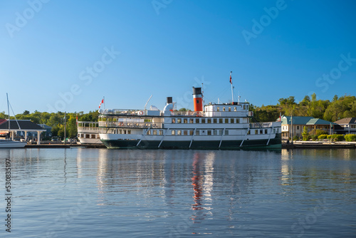 Photography Cruise steam ship moored by the pier at a small tourist town waterfront
