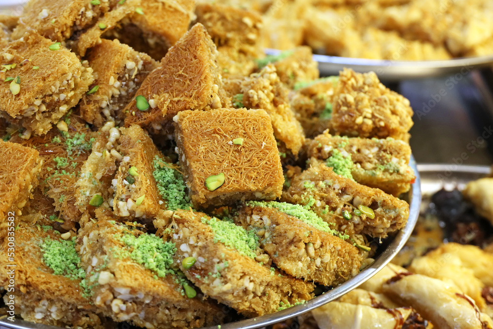Baklava with pistachios and peanuts, sweet background. Traditional turkish and arabic dessert Kunafa with pistachio, nuts and honey Baklava with pistachios and peanuts, sweet background. Traditional turkish and arabic dessert Kunafa with pistachio, nuts and honey