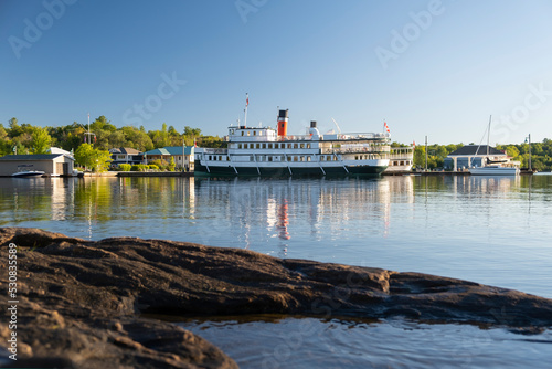 Canvas Print Cruise steam ship moored by the pier at a small tourist town waterfront