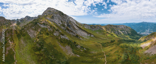Alpine Meadows Trail, Krasnaya Polyana Resort. Alpine Meadows Walking Route. Aerial view of the green mountain valley, surrounded by high mountains.