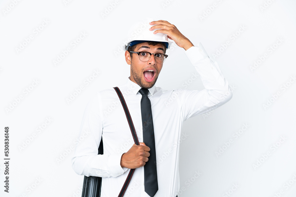 Architect brazilian man with helmet and holding blueprints doing surprise gesture while looking to the side Architect brazilian man with helmet and holding blueprints doing surprise gesture while looking to the side