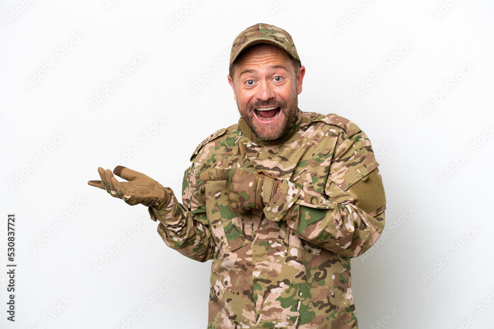Military man isolated on white background surprised and pointing side Military man isolated on white background surprised and pointing side