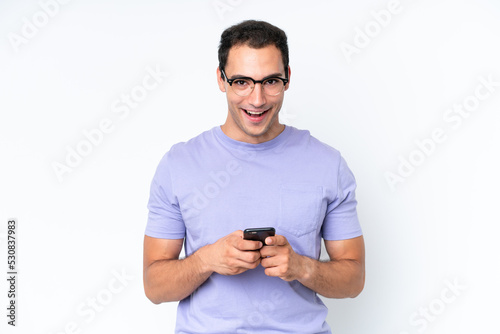 Young caucasian man isolated on white background surprised and sending a message