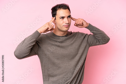 Young caucasian man isolated on pink background having doubts and thinking