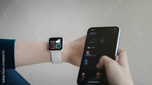 Close-up on smart watch wear on wrist screen show heartbeat tracking technology, walking step, time, weather for data health checking with Fitness Activity App.