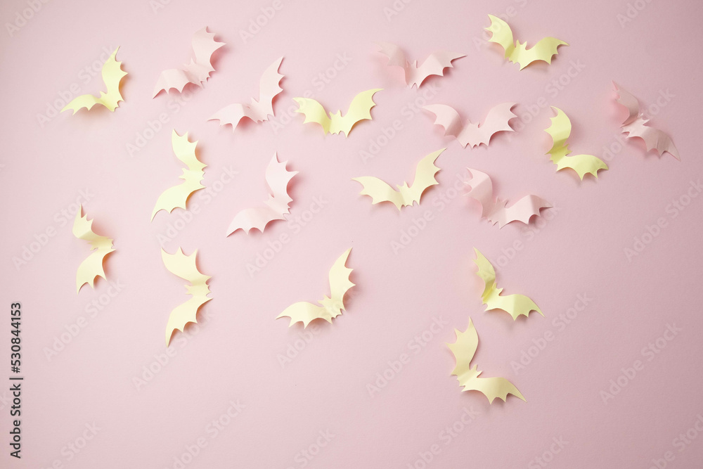 small light pink bats on a pink background with a place for text, the concept of a creative happy Halloween