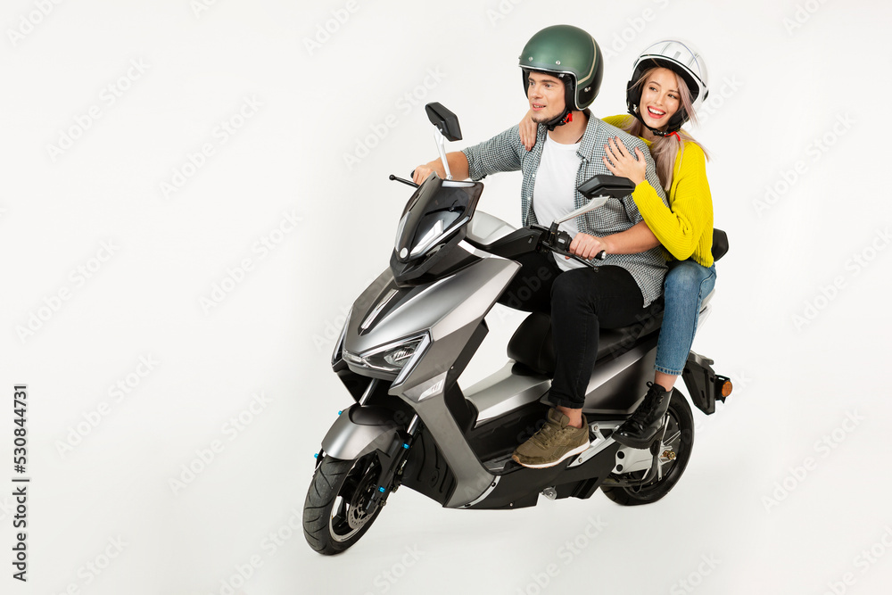 young attractive couple riding an electric motorbike scooter happy having fun together