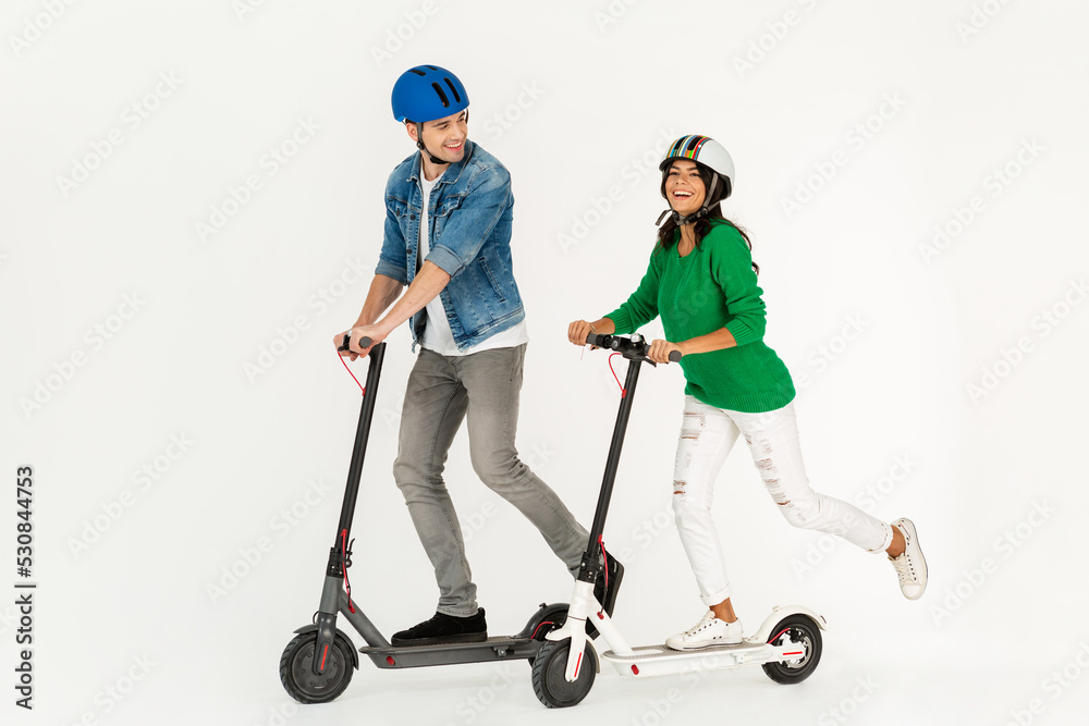 a couple riding on electic kick scooter isolated on white studio background a couple riding on electic kick scooter isolated on white studio background