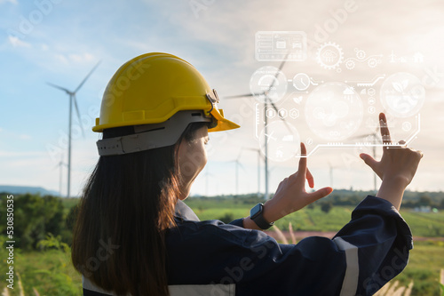 Close up engineering woman hand is touching virtual reality Analytics engineering data in a field over electrical turbines background photo