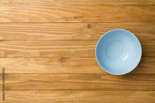 Empty round plate on wooden background, top view