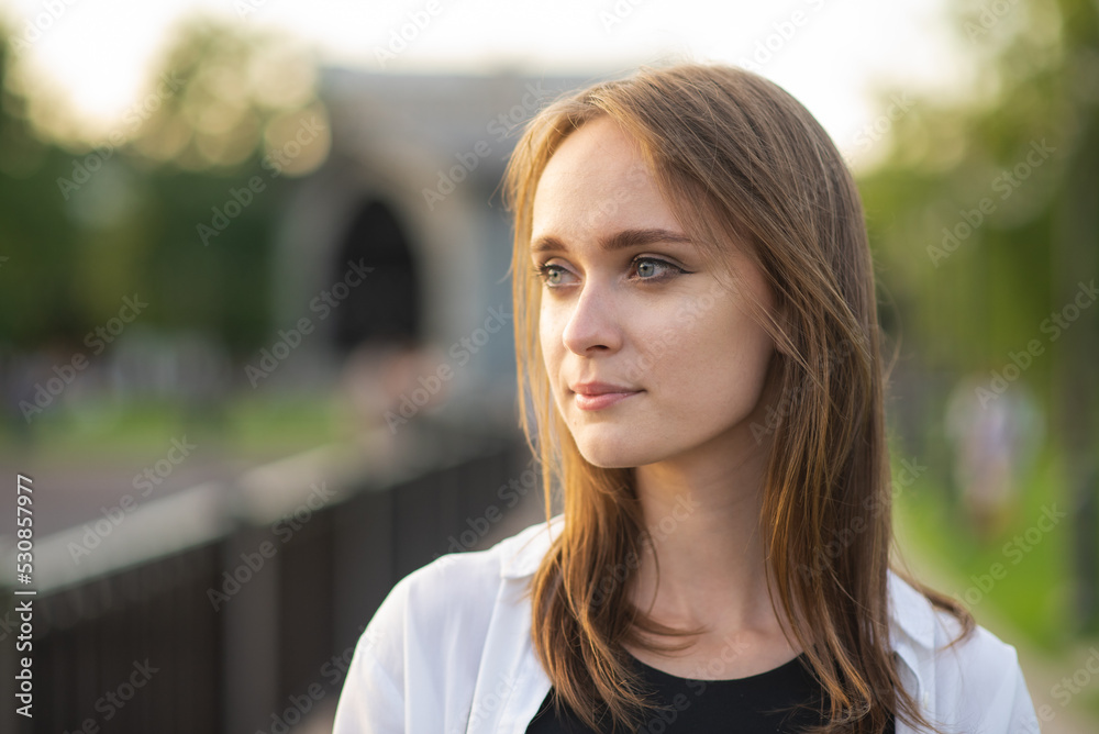 Close-up portrait of an attractive and young Caucasian girl in casual clothes in the park or on the street. Close-up portrait of an attractive and young Caucasian girl in casual clothes in the park or on the street.