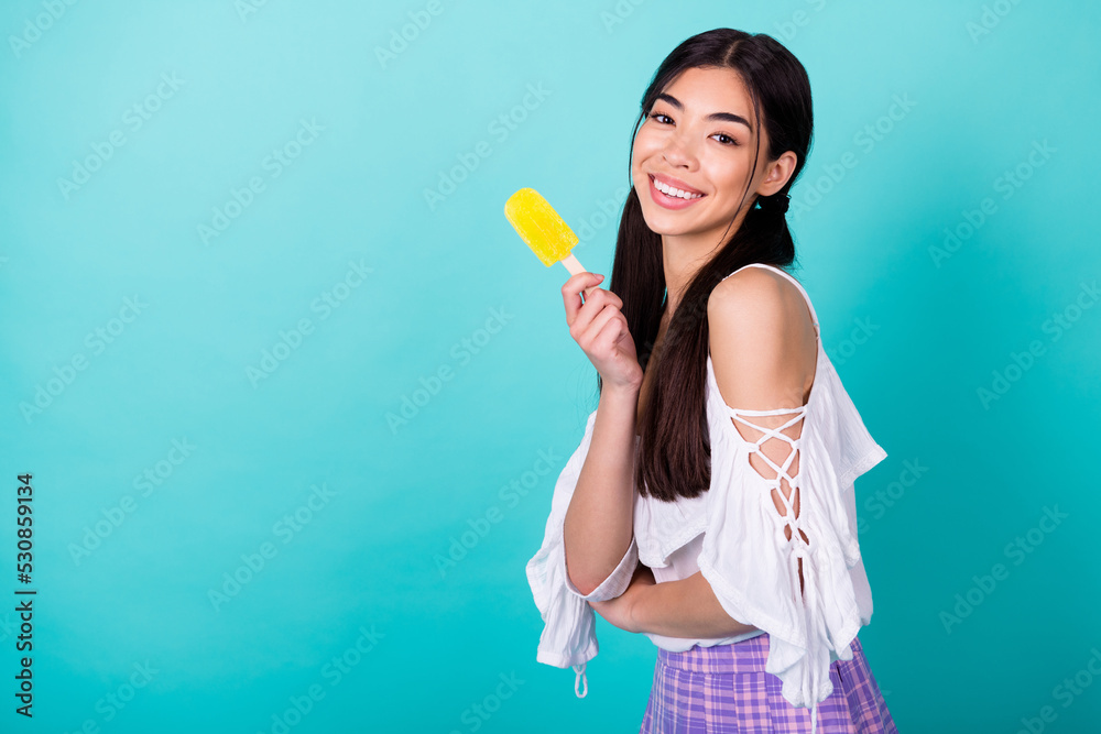 Photo of pretty lovely lady enjoying summer holiday hold fruity popsicle frozen yogurt isolated cyan color background Photo of pretty lovely lady enjoying summer holiday hold fruity popsicle frozen yogurt isolated cyan color background