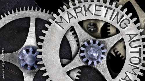 Group of rotating tooth wheels with Marketing Automation sign imprinted on metal surface. Concept of Technology and Industrial Innovation. High quality 4k video.