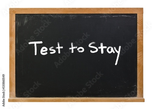 Test to stay written on a black chalkboard isolated on white