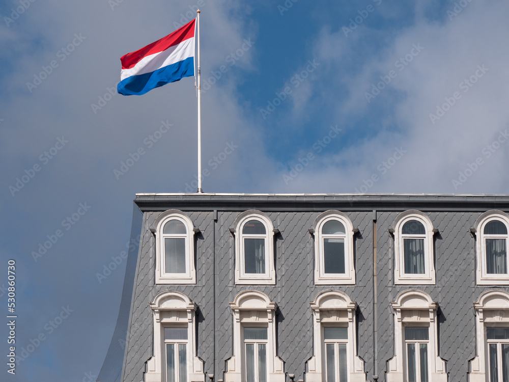Fototapeta premium Dutch flag blows in the wind over the roof