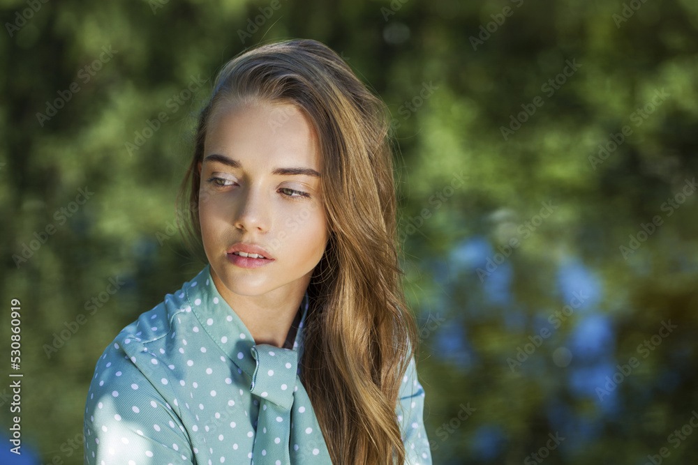 Close up portrait of a young beautiful woman in a turquoise dress Close up portrait of a young beautiful woman in a turquoise dress
