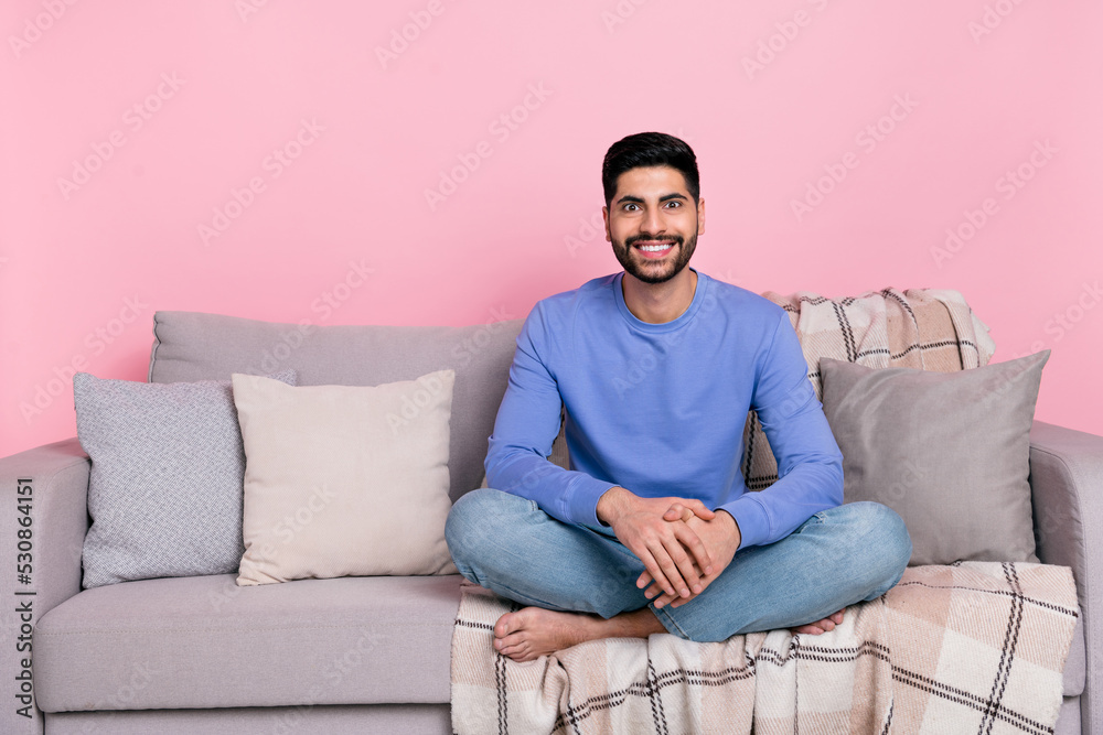 Photo of sweet shiny arab guy dressed blue pullover sitting couch empty space isolated pink color background Photo of sweet shiny arab guy dressed blue pullover sitting couch empty space isolated pink color background