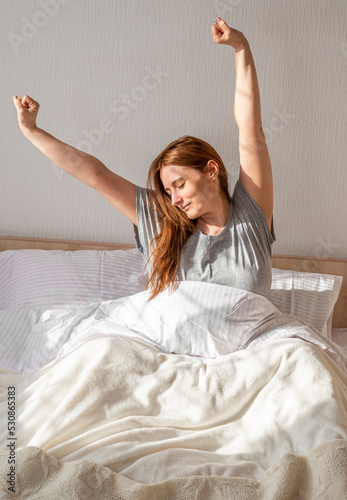 Принти на полотні Woman just waking up and stretching in bed at home in the morning