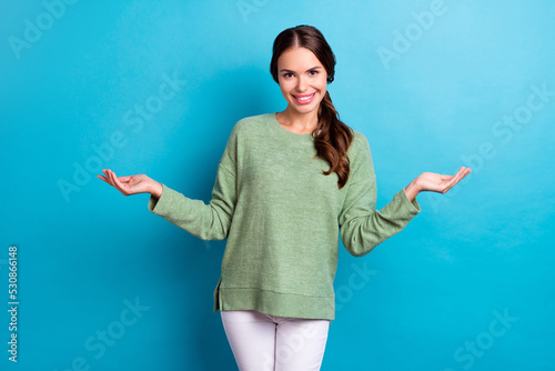 Portrait of cheerful nice lady arms hold empty space vs scales toothy smile isolated on blue color background