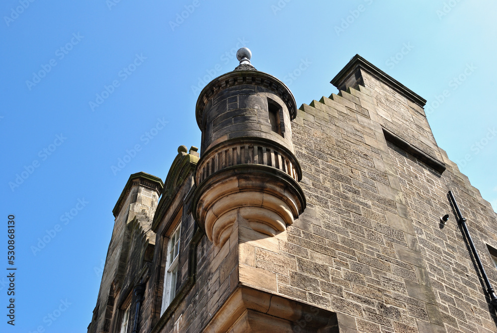 Old Stone Building with Circular Tower seen against Blue Sky from below