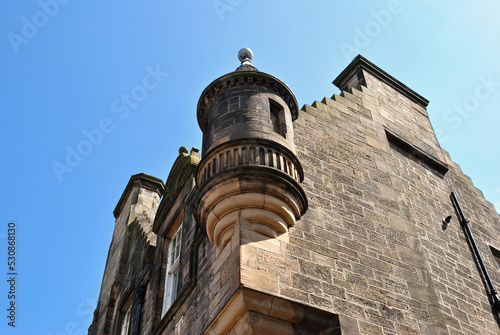 Fotografie, Tablou Old Stone Building with Circular Tower seen against Blue Sky from below