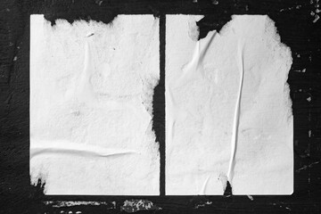 Two sheets of paper taped to a black wall.