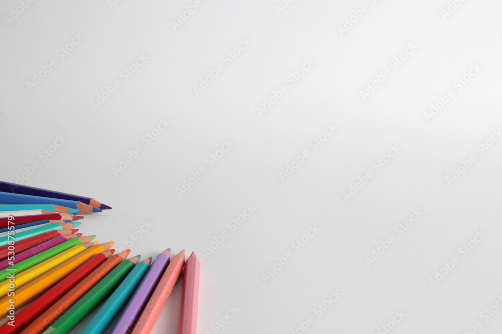 Fototapeta premium Set of colored pencils on white background. Pencils of various colors aligned to the left in circular shape.