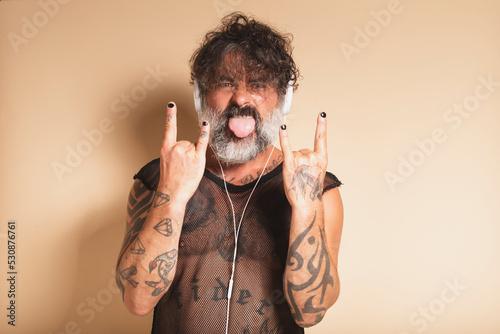 Bearded man showing rock gesture and listening to music photo
