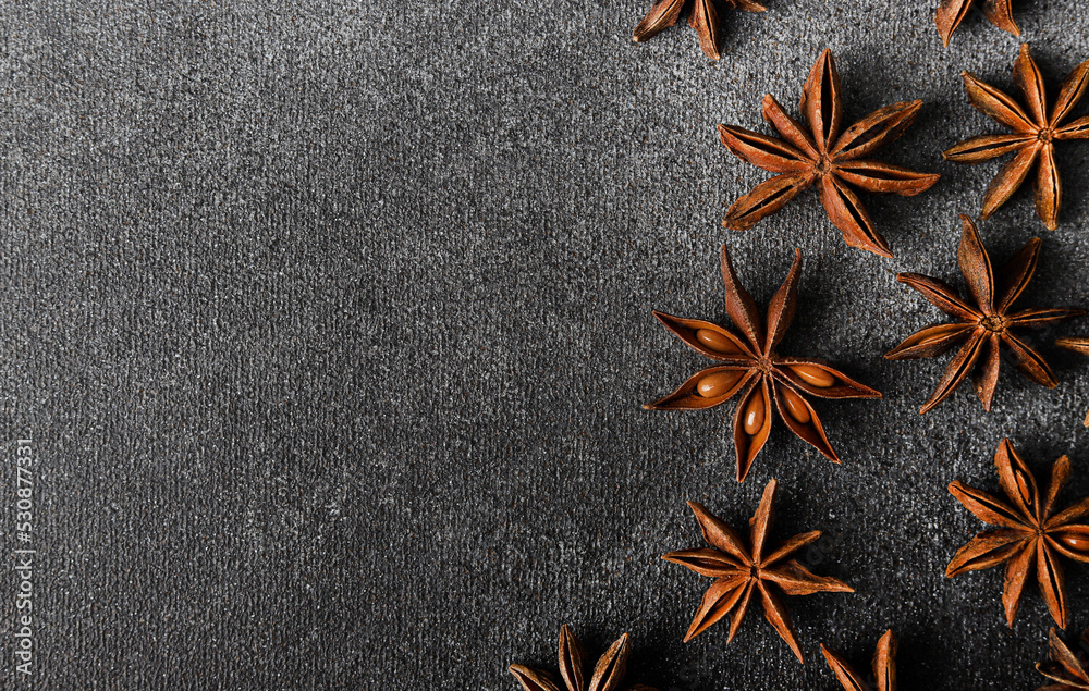 Star anise close up. Dark gray background with anise stars. Star anise close up. Dark gray background with anise stars.